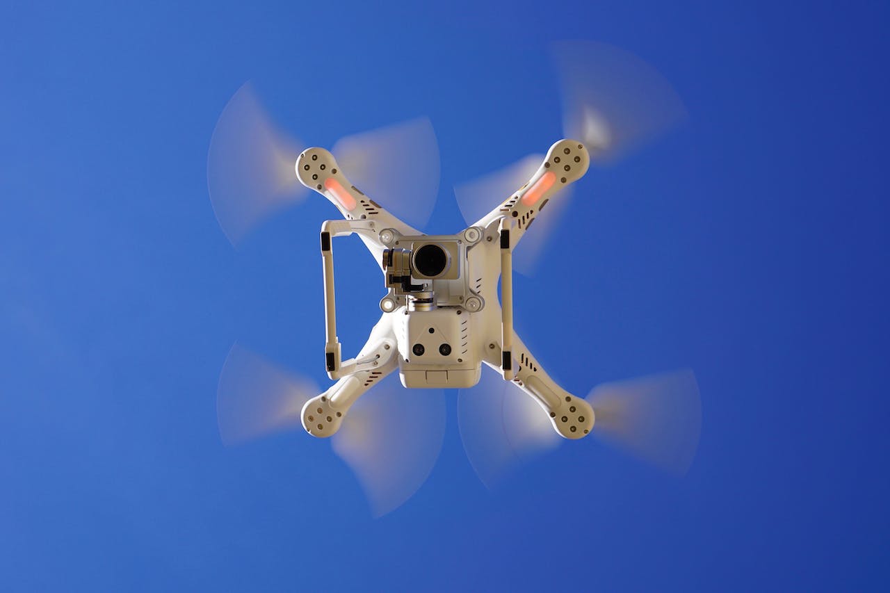 a drone flying against a blue sky